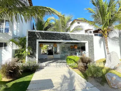 a white house with palm trees in front of it at Estrella Dominicus Apartamento - Bayahibe in Bayahibe