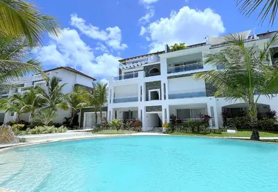 a large white building with a swimming pool in front of it at Estrella Dominicus Apartamento - Bayahibe in Bayahibe