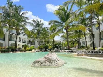 a rock in the water in front of a resort at Estrella Dominicus Apartamento - Bayahibe in Bayahibe