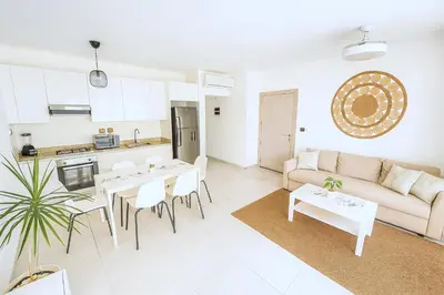 a living room with a couch and tables and a kitchen at Estrella Dominicus Apartamento - Bayahibe in Bayahibe