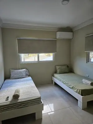 two beds in a room with two windows at Full Department 2 in Las Terrenas