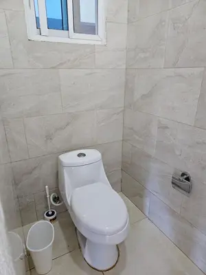a bathroom with a white toilet and a window at Full Department 2 in Las Terrenas