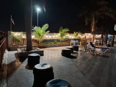 a patio at night with chairs and tables and lights at villa cueva del padre pio in Santiago de los Caballeros