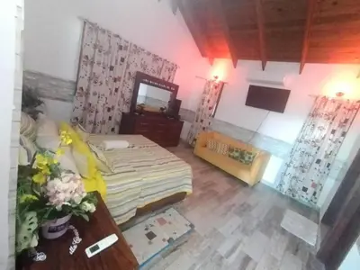 a bedroom with a bed and a table and a mirror at villa cueva del padre pio in Santiago de los Caballeros