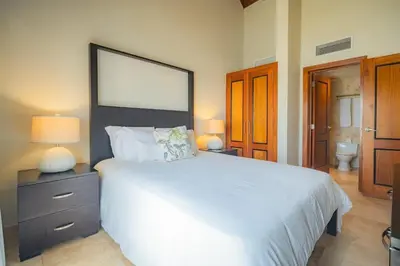 a bedroom with a large white bed and a bathroom at Penthouse Suite at Puerto Bahia in Samana in Los Grini