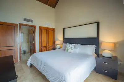 a bedroom with a large white bed and two lamps at Penthouse Suite at Puerto Bahia in Samana in Los Grini