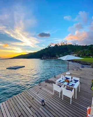 a wooden dock with a table and chairs on the water at Penthouse Suite at Puerto Bahia in Samana in Los Grini