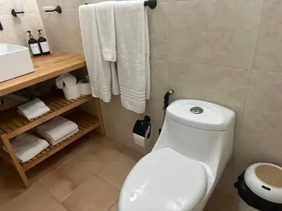 a bathroom with a toilet and a sink and towels at Villa Paz in La Romana