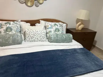 a bed with blue and white pillows on top of it at Villa Paz in La Romana