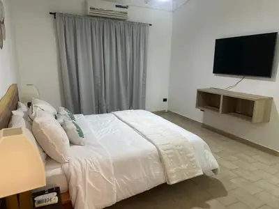a bedroom with a bed and a flat screen tv at Villa Paz in La Romana