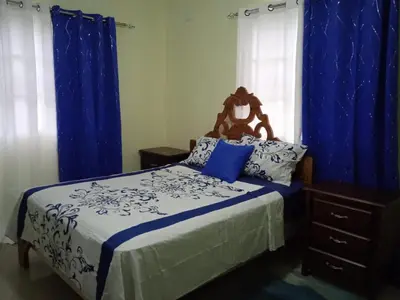 a bedroom with a bed with blue and white sheets at Casa de alquiler FIGARO in Villa Clara