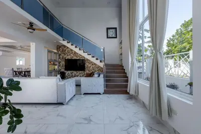 a living room with a staircase and a large window at Luxurious Home with Pool in San Felipe de Puerto Plata