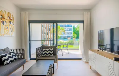 a living room with a couch and a sliding glass door at Bran new condo with pool access in Punta Cana
