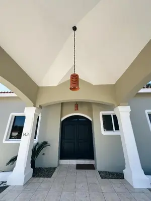 a front door of a house with a black door at Casa Caipirinha Encuentro in Cabarete