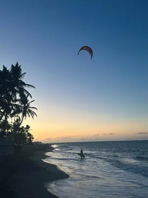 a person is flying a kite on the beach at Casa Caipirinha Encuentro in Cabarete