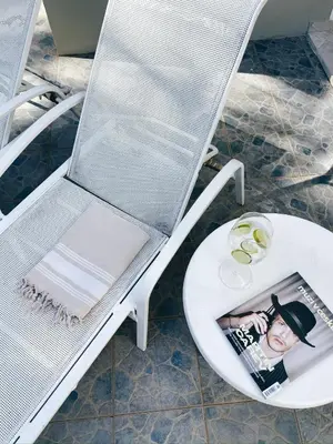 a white chair with a magazine sitting on a table at Casa Caipirinha Encuentro in Cabarete