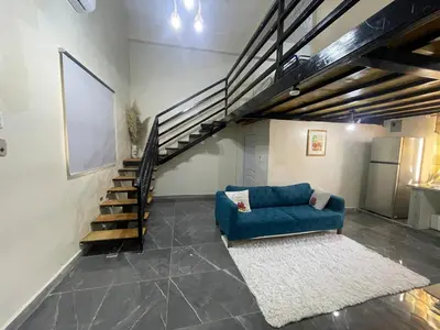 a living room with a blue couch and stairs at Loft's R&L in Juan de Herrera