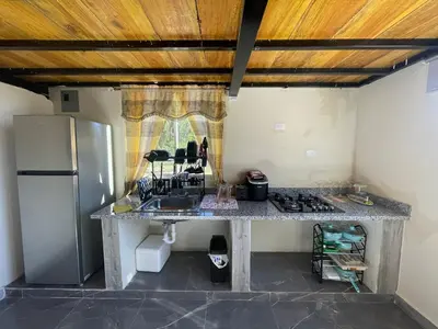 a kitchen with a counter with a sink and a refrigerator at Loft's R&L in Juan de Herrera