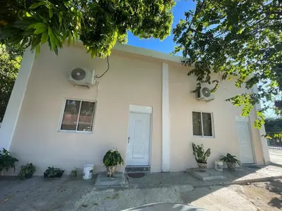 a white house with a dog sitting in front of it at Loft's R&L in Juan de Herrera