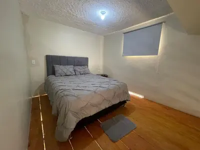 a bedroom with a bed in a white room at Loft's R&L in Juan de Herrera