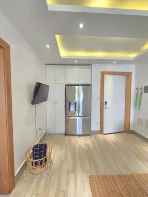 an empty living room with a refrigerator and a television at Beautiful Apartment 10 min from Bayahibe beach Las Terrazas in Bayahibe