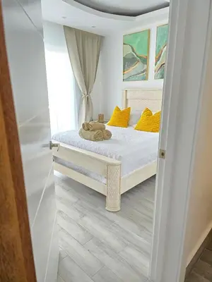 a bedroom with a bed with yellow pillows at Beautiful Apartment 10 min from Bayahibe beach Las Terrazas in Bayahibe