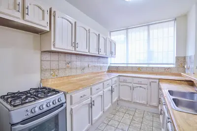 a kitchen with white cabinets and a stove top oven at A Beautiful Studio Apartments Furnished in Gascue in Santo Domingo