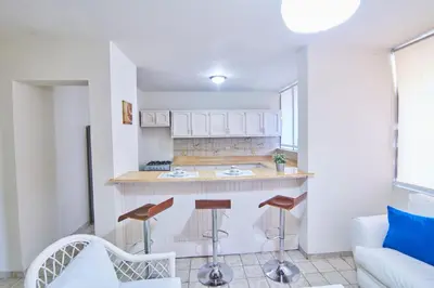 a kitchen with a counter and stools in a room at A Beautiful Studio Apartments Furnished in Gascue in Santo Domingo