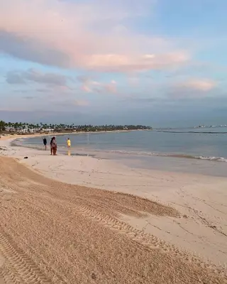 a group of people walking on the beach at Un Lugar Único y Céntrico RD Los Corales in Punta Cana