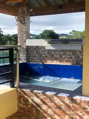 a swimming pool in a house with a stone wall at Casa lopez in Jarabacoa