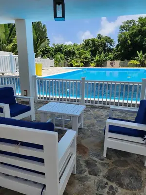 a patio with chairs and a swimming pool at Bella Villa Apart for 2 with kitchen pool and close to the beach in Las Galeras