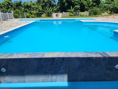 a swimming pool with blue water at Bella Villa Apart for 2 with kitchen pool and close to the beach in Las Galeras