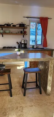 a kitchen with a large stone counter with a bench at Bella Villa Apart for 2 with kitchen pool and close to the beach in Las Galeras
