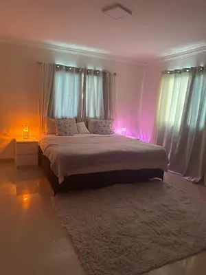a bedroom with a large bed with pink lights at Gran Apartamento frente al mar in La Francia