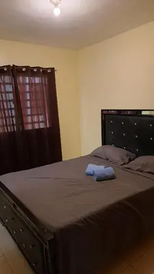 a bedroom with a large bed with a blue towel on it at Ciudad Juan Bosch StoDgo este in La Javilla