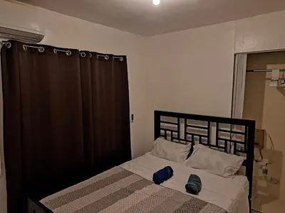 a bedroom with a bed with two blue shoes on it at Ciudad Juan Bosch StoDgo este in La Javilla
