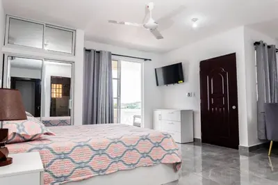 a bedroom with a bed and a flat screen tv at Villas Hillside apt 4 in Santa Bárbara de Samaná