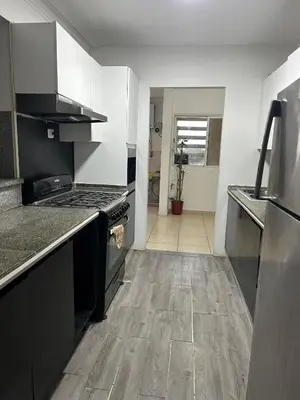 a kitchen with black appliances and a wooden floor at Vista al Caribe in La Francia