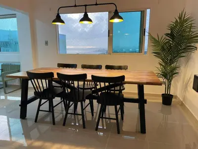 a wooden dining room table with chairs and a potted plant at Vista al Caribe in Los Mameyes