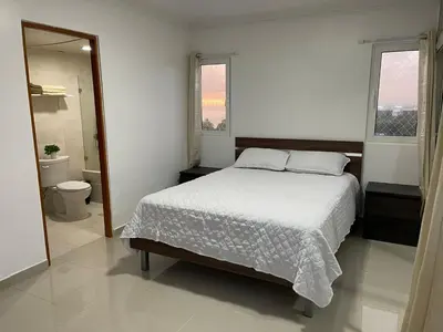 a bedroom with a bed and a bathroom with a toilet at Vista al Caribe in Los Mameyes