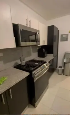 a kitchen with a stove and a microwave at Vista al Caribe in Los Mameyes