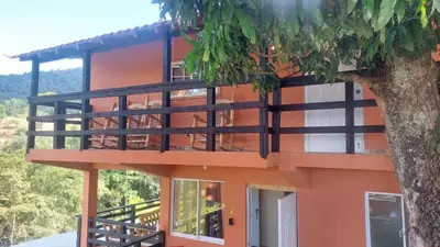 an orange building with a tree in front of it at Vista Montaña Jimenoa De La Rosa in Jarabacoa