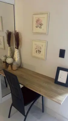 a desk with a chair and some pictures on the wall at Heaven apart cerca del aeropuerto parqueo incluído TAXI DISPONIBLE in Monte Adentro