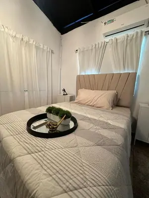 a white bed with a bowl of plants on it at Villa Canaan in Pedro Brand