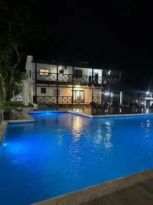 a swimming pool in front of a building at night at Villa Canaan in Pedro Brand
