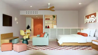 a bedroom with a bed and a couch and chairs at Fiesta Americana Funeeq Punta Cana All Inclusive in Punta Cana