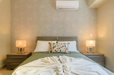 a bedroom with a bed with two nightstands and two lamps at Charming space in the city center in Santo Domingo
