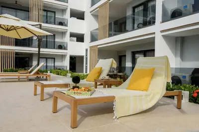 a hotel patio with chairs and a table and an umbrella at Amazing pool views apartment in Playa Bavaro in Punta Cana