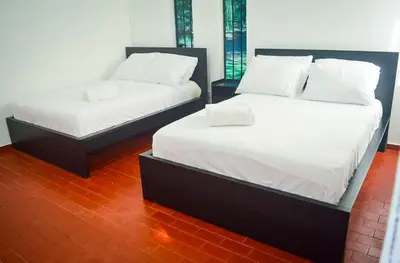 two beds in a room with white sheets at Villa moderna 95 in San José de Las Matas
