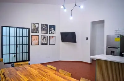 a room with a kitchen with a table and a refrigerator at Villa moderna 95 in San José de Las Matas